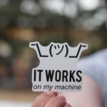 Man Holding a Sticker with a Programming Meme